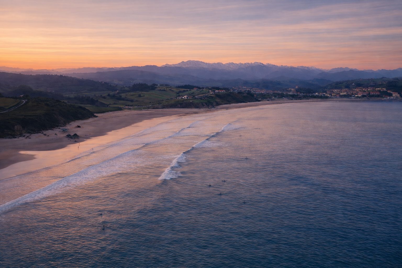 vista de la playa de oyambre con montañas al fondo en cantabria